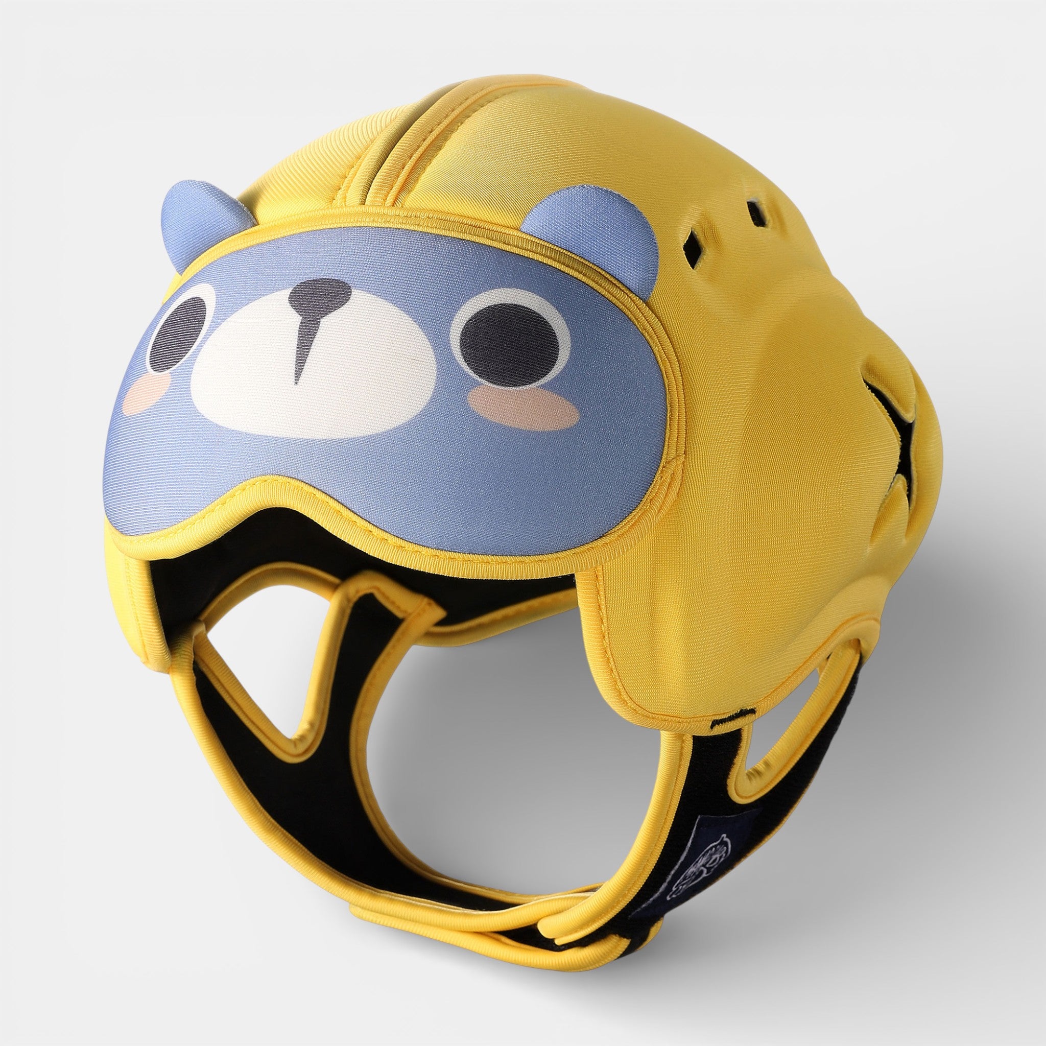 A baby wearing the bear-themed Head Guard baby head protector helmet, featuring padded forehead peaks and air vents for cooli