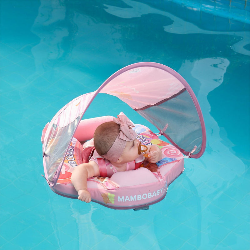Candy rainbow Mambobaby float in pool at the beach. Infant wearing foam-core non-inflatable float with UPF canopy.