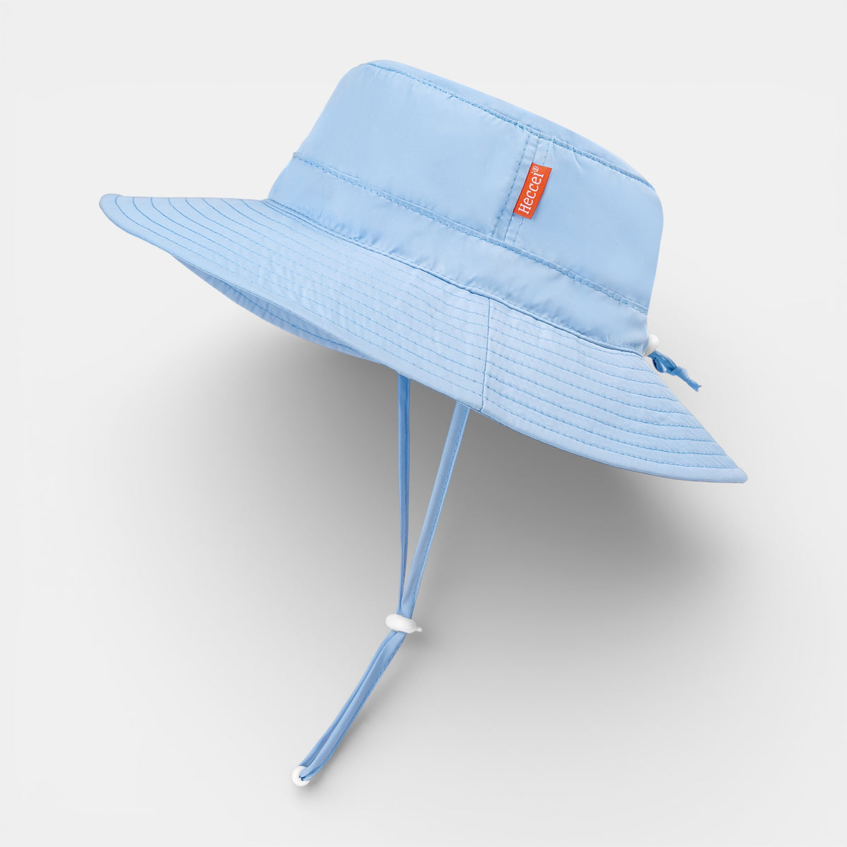Baby in blue PackNest Sun Hat with UPF 50+ protection, breathable quick-dry fabric, and adjustable fit for travel-ready sun s